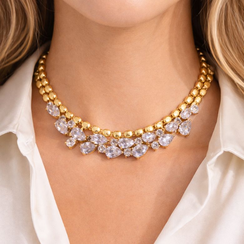 Close-up of an elegant, adjustable choker necklace with silver teardrop rhinestones, featuring a gold stainless steel finish.