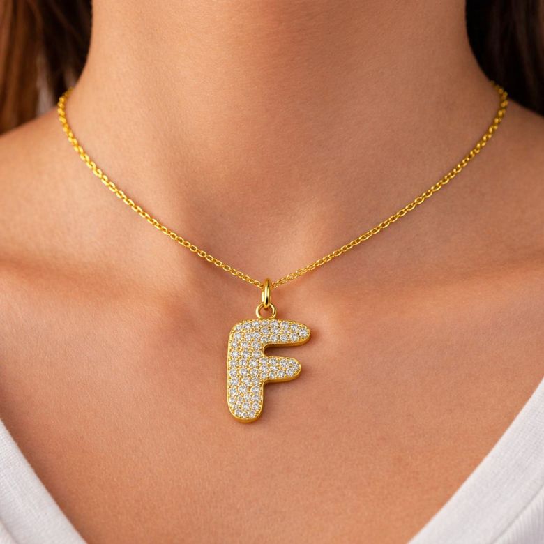 Collana lettera A acciaio dorato e strass. Pendente indossato.