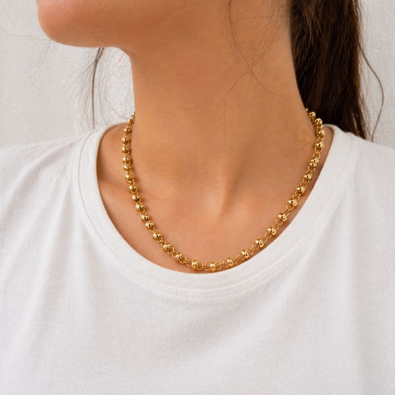 Collana maglia nodi acciaio dorato elegante indossata. Design moderno.