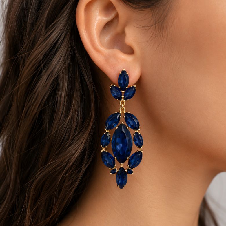 Orecchini blu pendenti con pietre a goccia e motivo floreale dorato indossati.